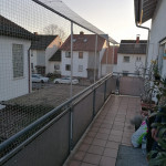 Un&uuml;berwindbares, hohes Katzen-Sicherheitsnetz an langem Balkon. Katzenschutznetz mit &Uuml;berdachung an Balkongel&auml;nder eines Hauses. Hohes Balkonnetz mit Barriere bietet mehr Sicherheit f&uuml;r Katzen.
