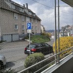 Katzengitter, Schutznetz sch&uuml;tzt Katzen vor Absturz und Autounfall. Innenansicht vom Balkon mit nahezu unsichtbarer Katzensicherung.