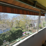 Katzenschutznetz am Balkon mit Markise. Langer Balkon wurde durch Montage eines Netzes katzensicher gemacht. Freie Sicht mit Sonnenschutz trotz Balkonnetz f&uuml;r Katzen.