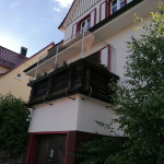 Katzenschutznetz netz an einem Fachwerkhaus angebracht. Katzengitter und Netz online bestellen plus Montage durch Firma aus NRW. Katzen-Schutznetz an Balkon mit Holz-Br&uuml;stung. Katzensicherung von Balkon, Terrasse, Fenster in alten, historischen H&auml;usern.